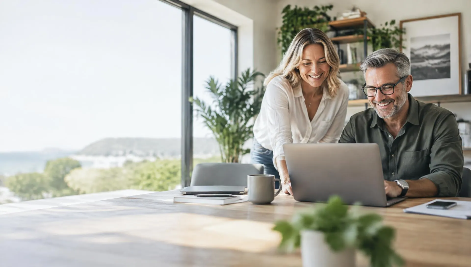 Smiling business owners working together on a laptop in a bright home office